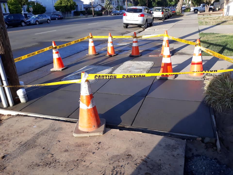A wet pavement floor with caution wrap around some cones