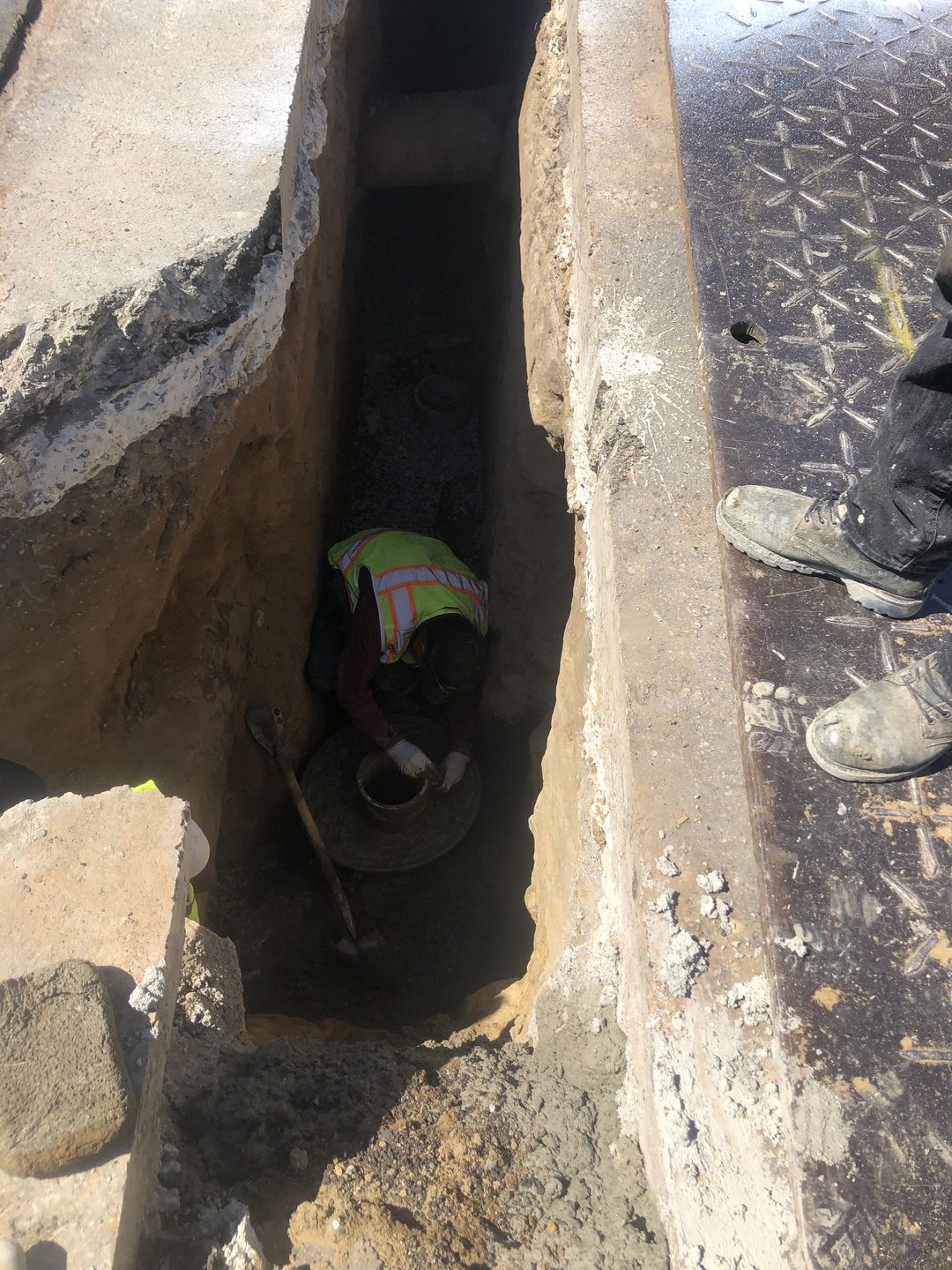 A worker underground inspecting pipes